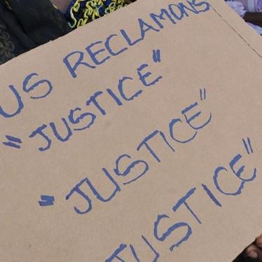 Victims of the 2010-2011 post-election crisis hold placards reading 'We claim justice, justice justice' at a gathering in the Kouassai district of Abidjan on February 28, 2013,