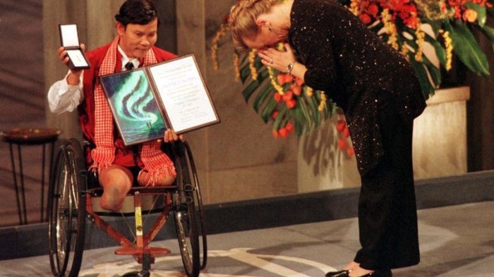 The winner of the Nobel Peace Prize Jody Williams bows in front of Cambodian Tun Channereth, who holds the International Campaign to Ban Landmines diploma and medal, on her way to receive the Nobel Peace Prize in Oslo City Hall, December 10, 1997.