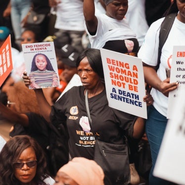 A woman is seen holding protest signs during the #EndFemicideKE and #TotalShutdownKE march in Nairobi, Kenya, January 27, 2024.