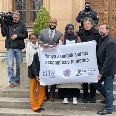 A group of people standing on steps hold a sign