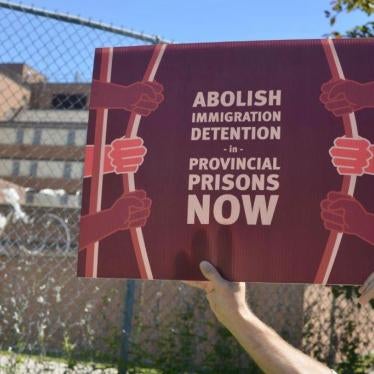 A protestor holds a sign outside a provincial jail in Toronto.