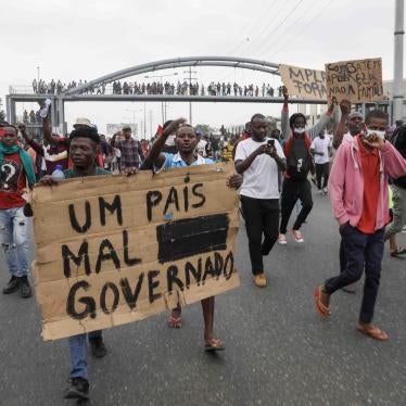 People hold up a sign that reads “A country badly governed” during a march against rising fuel prices and the end of street vending in Luanda, Angola, June 17, 2023. © 2023 ROGERIO/EPA-EFE/Shutterstock