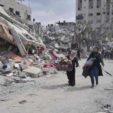 Palestinian women walk by buildings destroyed in Israeli airstrikes in Nuseirat camp in the central Gaza Strip, October 16, 2023.