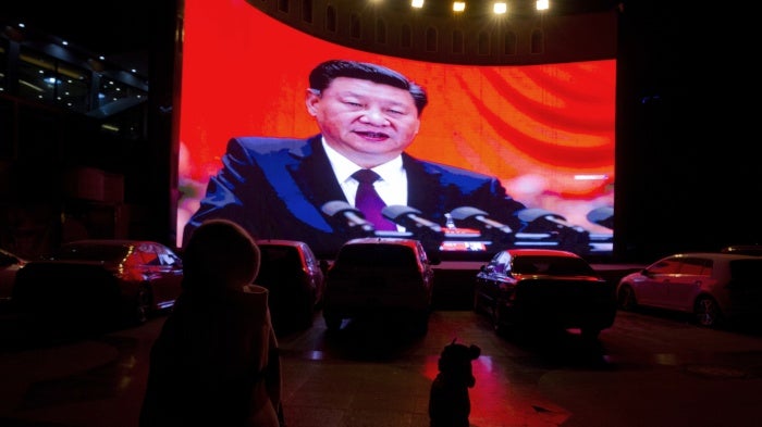 A large screen shows Chinese President Xi Jinping near a carpark in Kashgar, in western China's Xinjiang region