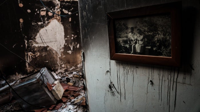 A framed family photo hung up on the wall of a burned home