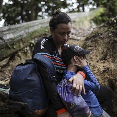 A woman embraces her son in a jungle