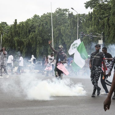 Demonstrators react as Nigerian policemen fire teargas canisters during the End Bad Governance protest in Abuja on August 1, 2024.