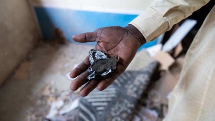 A resident of the Ridina district in N'Djamena shows the fragments of a projectile, that fell into a house on May 9, 2024, in N'Djamena following the announcement of the provisional results of the Chad presidential elections.