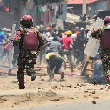 Armed riot police officers run towards protesters 