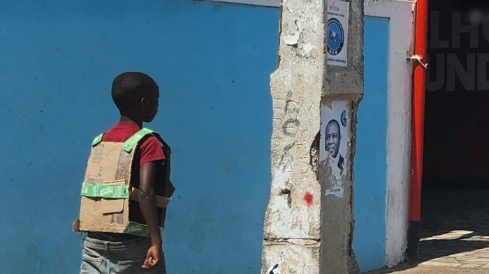 A boy wears a “bullet-proof vest” made of cardboard while walking on the streets of Maputo, Mozambique, November 5, 2024.