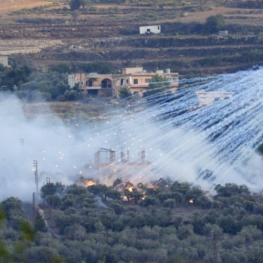 Artillery projectile containing white phosphorus bursts over a village