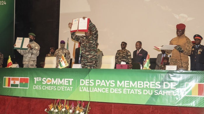 The leaders of Niger, Gen. Abdourahamane Tiani (C), Mali, Col. Assimi Goita (L), and Burkina Faso, Capt. Ibrahim Traore (R), show the documents of the Confederation of Sahel States, which they signed during their first summit in Niamey, Niger, July 6, 2024.