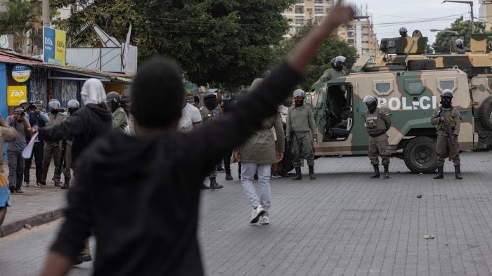 Riot police officers block a road