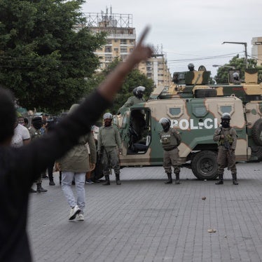 Riot police officers block a road