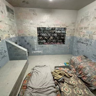 A detention cell with writing on its walls.