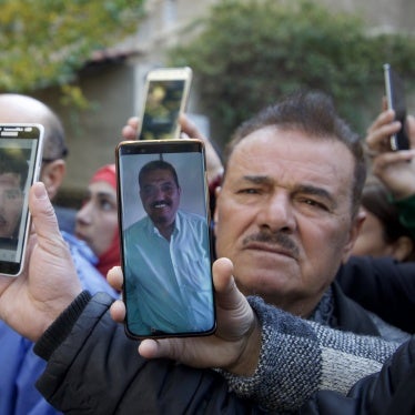 Family members of missing Syrian detainees hold up photos of their loved ones outside al-Mujtahid hospital in Damascus on December 15, 2024.