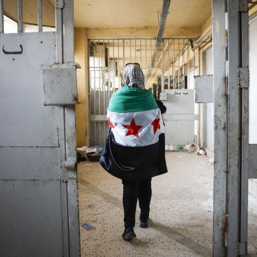 A woman wearing a Syrian opposition flag visits Sednaya prison near Damascus, Syria, December 12, 2024