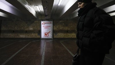 A woman walks past an election poster