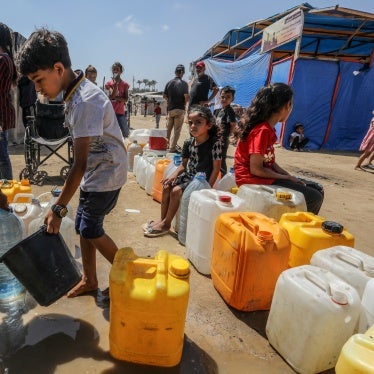 Palestinians wait to receive clean drinking water distributed by aid organizations in Deir al-Balah, Gaza, June 10, 2024.