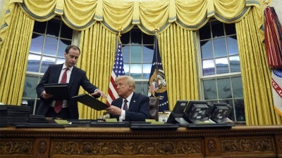 US President Donald Trump signs executive orders in the Oval Office of the White House in Washington DC, January 20, 2025. 