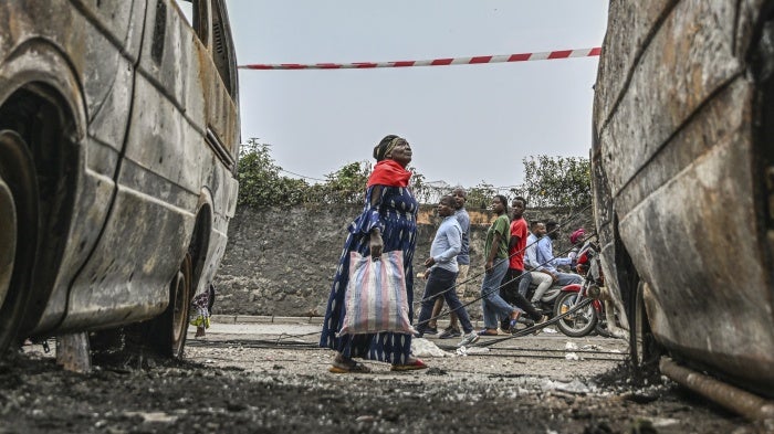 Residents walk by charred vehicles in Goma, Democratic Republic of Congo, January 31, 2025.