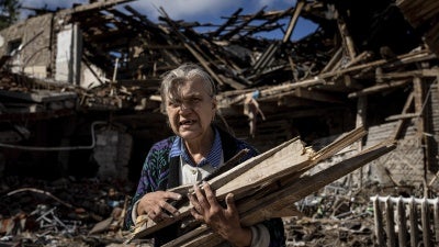 Eine Frau sammelt am 19. September 2022 in Izium, Ukraine, Holz zum Heizen in einer zerstörten Schule, in der russische Truppen stationiert waren.