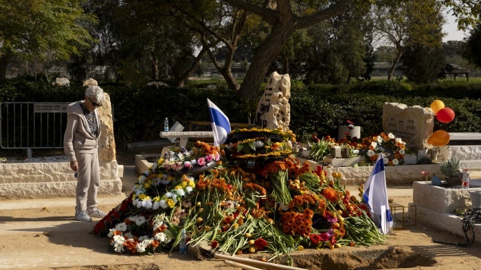 A mourner at the grave of hostages Shiri Bibas, Kfir Bibas and Ariel Bibas after their funeral on February 26, 2025, in Tzohar, Israel.