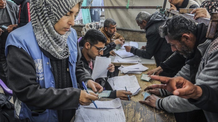 Palestinians receive humanitarian aid from the United Nations Relief 