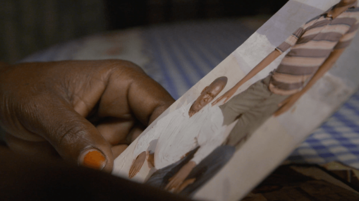 A photo of a woman holding the photo of disappeared relative. 