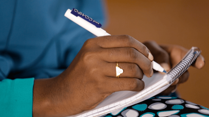 A picture of a hand writing on notepad.